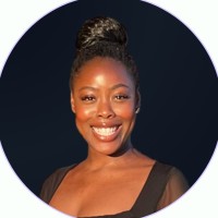 Smiling woman with a bun hairstyle, against a dark background.